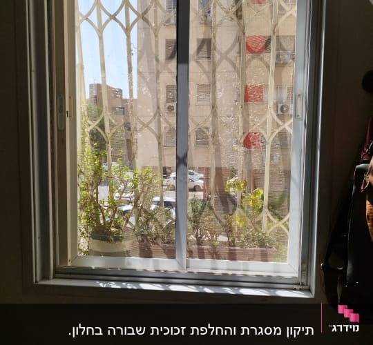 חלון עם תריסים פתוחים ומסגרת לבנה